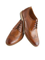 Pair of brown leather brogue shoes on a light background