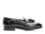 Handmade black leather tassel loafers for men with polished finish and almond toe.