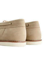 Pair of beige canvas shoes on a light gray background