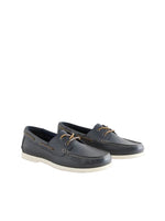 Pair of navy blue leather shoes with white soles on a light gray background