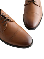 Brown leather dress shoes on a light background