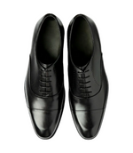 Pair of black dress shoes on a light gray background