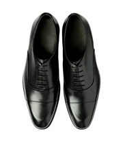 Pair of black dress shoes on a light gray background