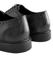 Pair of black leather brogue shoes on a white background