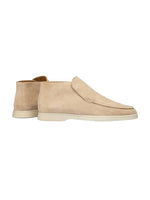 Beige suede loafers on a white background