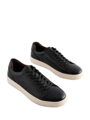 Pair of black leather sneakers on a light gray background