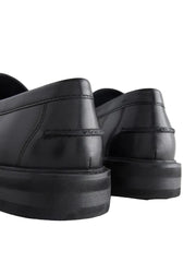 Black leather shoes with thick soles on a light background