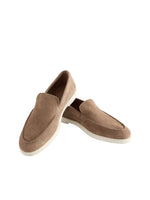 Pair of brown suede loafers on a light gray background