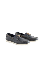 Pair of navy blue leather shoes with white soles on a light gray background