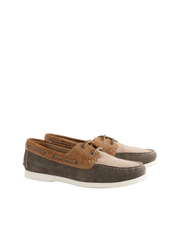 Pair of brown and beige boat shoes on a light gray background