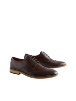 Pair of brown leather dress shoes on a light gray background