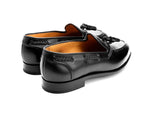 Handcrafted black leather tassel loafers featuring braided side accents and elegant silhouette.