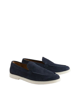 Pair of navy loafers on a light beige background